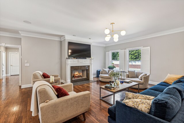 living room with a premium fireplace, crown molding, dark hardwood / wood-style floors, and an inviting chandelier