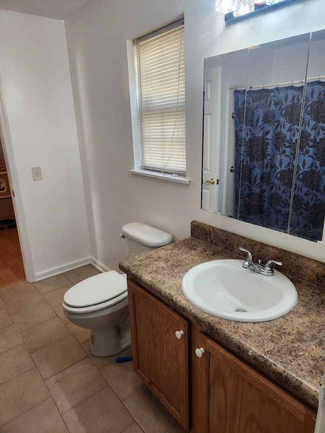 bathroom featuring vanity, toilet, and tile patterned flooring