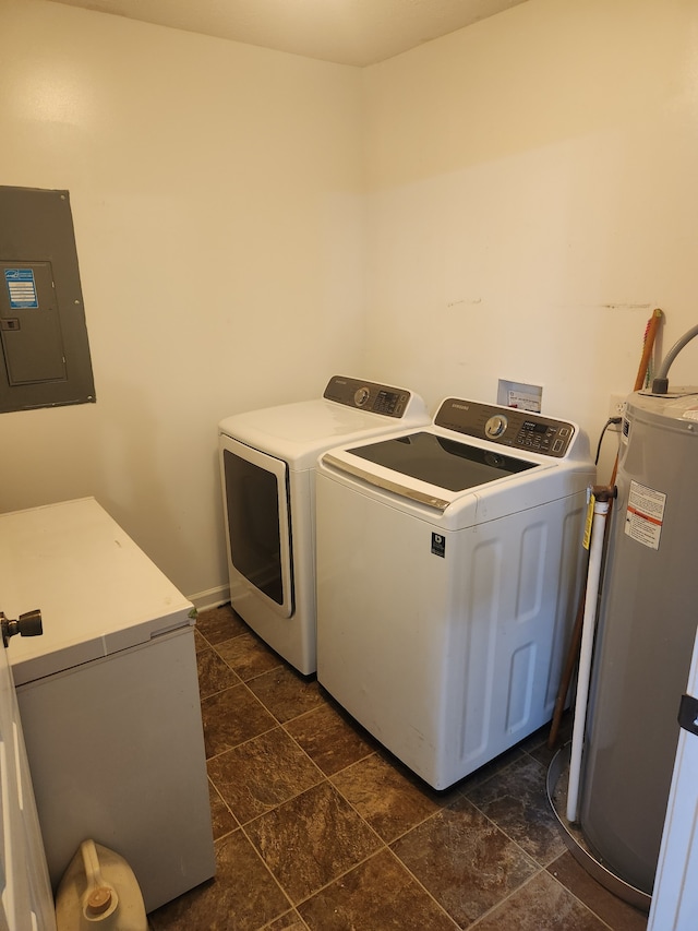 laundry room with water heater, washer and dryer, electric panel, and dark tile patterned floors