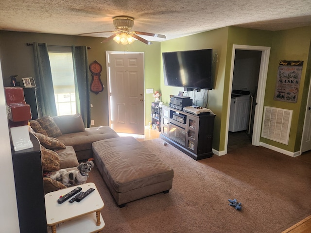 carpeted living room with washer and dryer, a textured ceiling, and ceiling fan