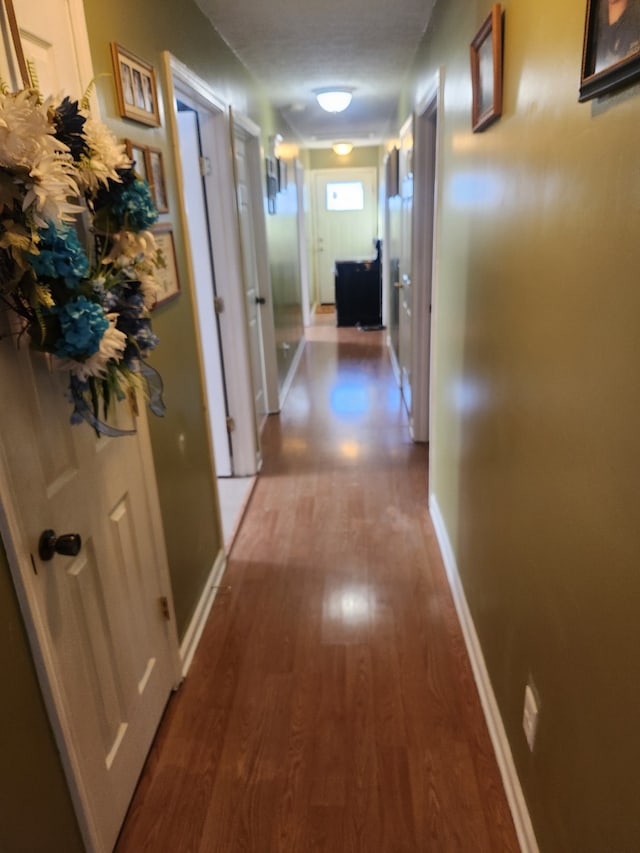 hall featuring a textured ceiling and hardwood / wood-style floors