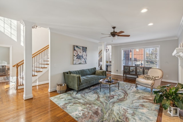 living room with light hardwood / wood-style flooring, ceiling fan, ornate columns, and crown molding