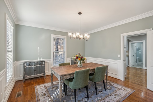 dining area featuring crown molding, dark hardwood / wood-style floors, a notable chandelier, and plenty of natural light