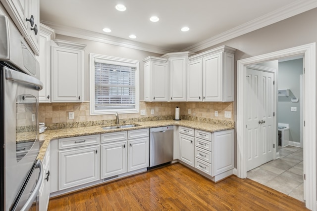 kitchen with white cabinetry, dishwasher, and wood-type flooring