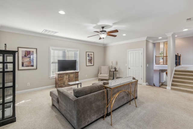 carpeted living room featuring decorative columns, ornamental molding, and ceiling fan