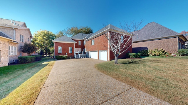 view of side of property featuring a yard, a garage, and central AC unit