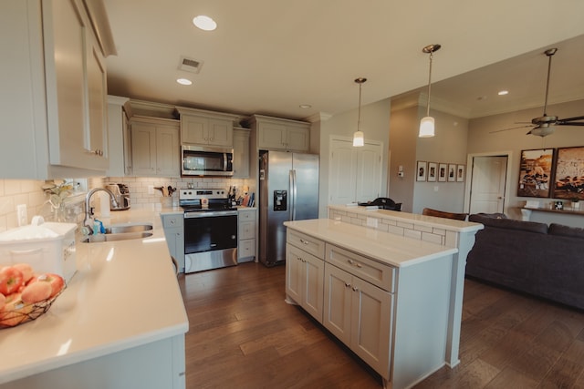 kitchen with appliances with stainless steel finishes, sink, a kitchen island, and dark hardwood / wood-style flooring