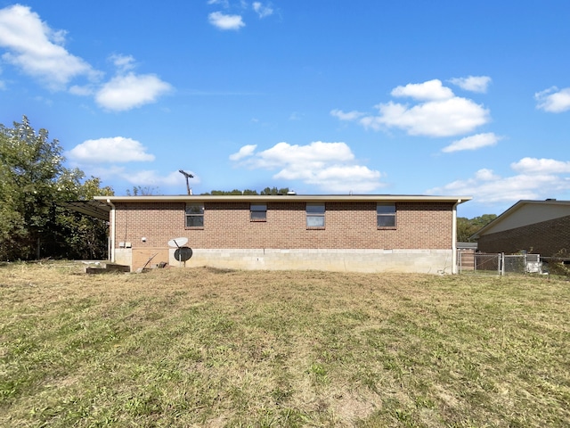 rear view of property featuring a lawn