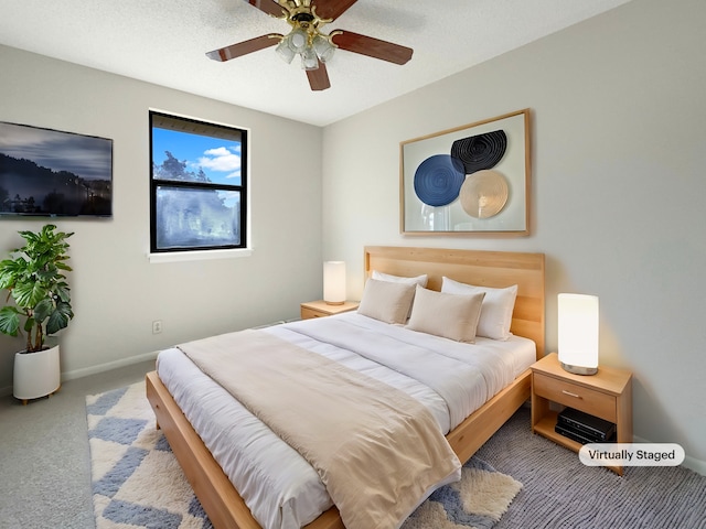 carpeted bedroom featuring ceiling fan and a textured ceiling