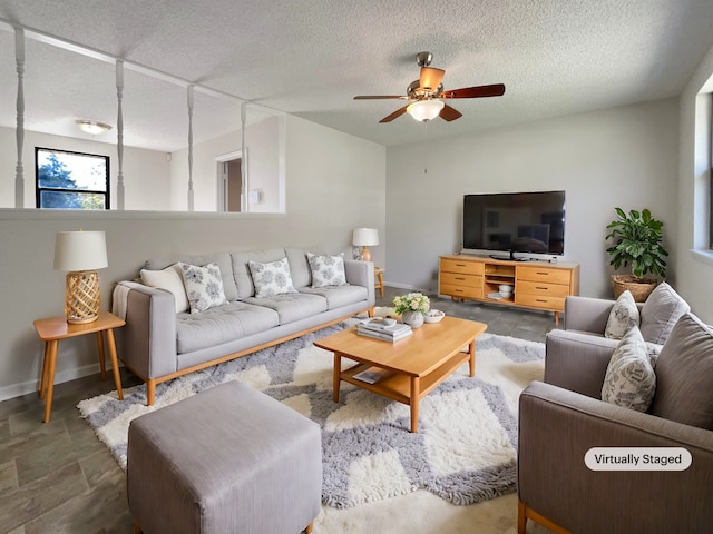 living room with ceiling fan and a textured ceiling