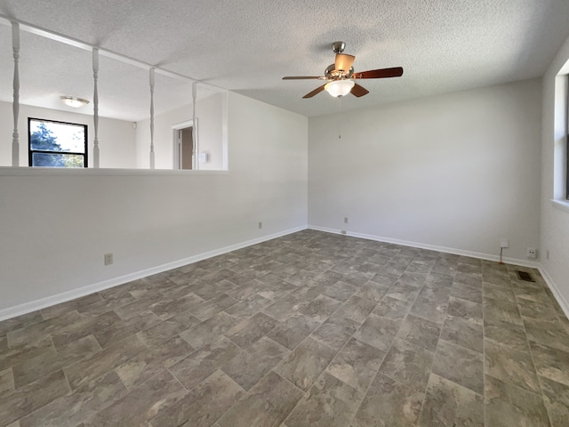 empty room with a textured ceiling and ceiling fan