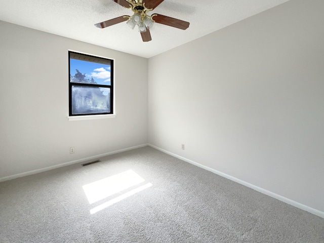 carpeted empty room featuring ceiling fan and a textured ceiling