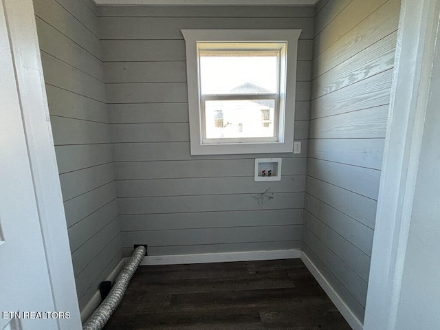 washroom featuring dark wood-type flooring, washer hookup, and wooden walls