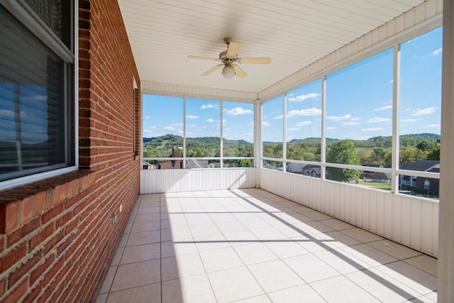 unfurnished sunroom featuring a healthy amount of sunlight and ceiling fan