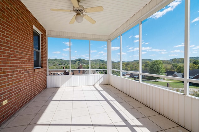 unfurnished sunroom with ceiling fan