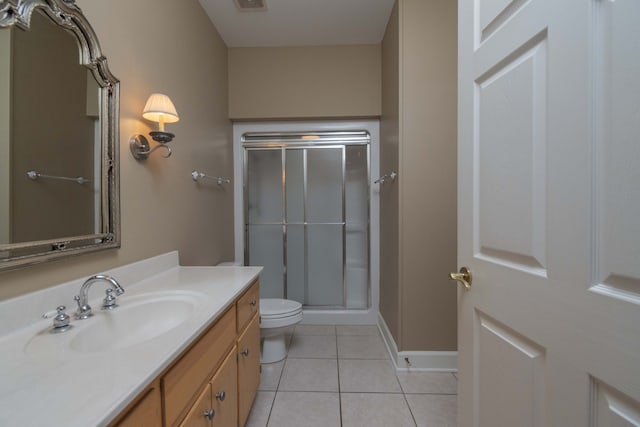 bathroom with toilet, a shower with shower door, vanity, and tile patterned flooring