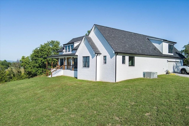 rear view of house with central AC unit, a lawn, and a porch