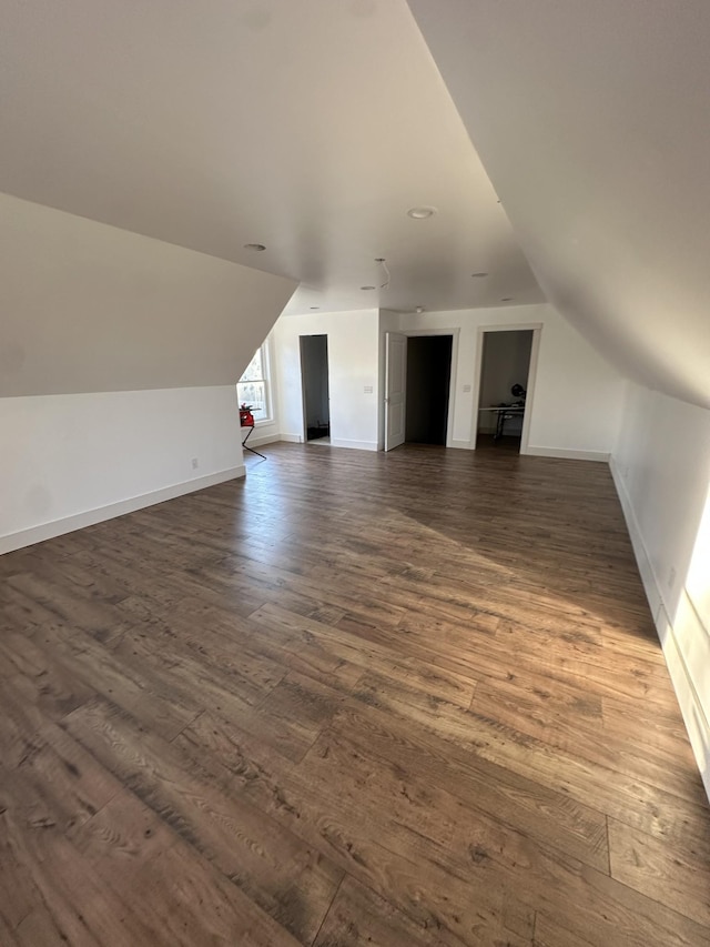 bonus room featuring dark wood-type flooring and lofted ceiling