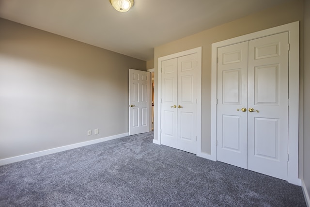 unfurnished bedroom featuring multiple closets and dark carpet