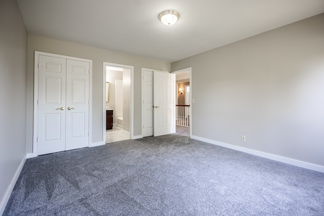 unfurnished bedroom featuring connected bathroom and carpet