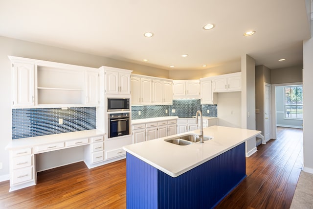 kitchen with a kitchen island with sink, white cabinets, sink, and stainless steel appliances