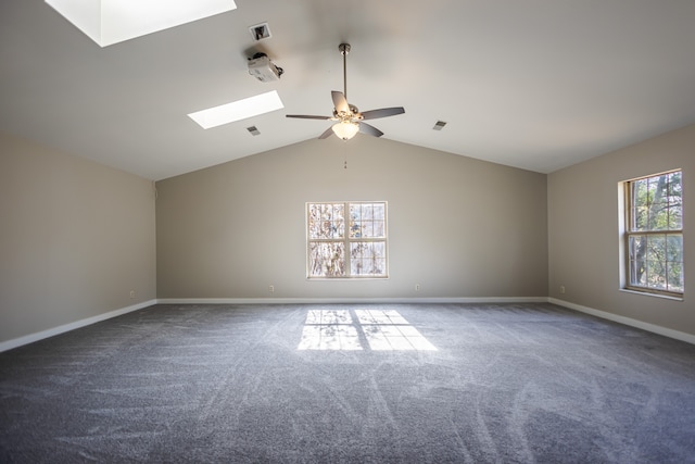 carpeted spare room featuring a wealth of natural light, ceiling fan, and lofted ceiling with skylight