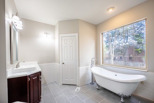 bathroom with vanity, tile walls, tile patterned flooring, and a bathing tub