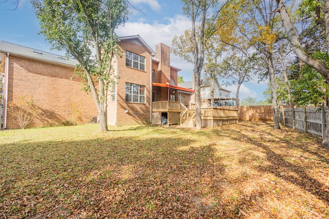 back of property with a yard and a wooden deck