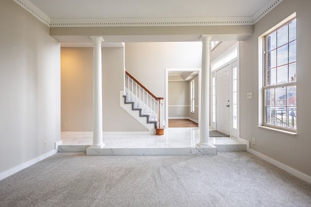 entryway with ornamental molding, a wealth of natural light, and light carpet