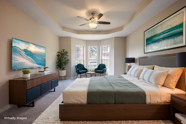 bedroom with a tray ceiling, carpet flooring, and ceiling fan