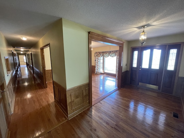 entryway with dark wood-type flooring and a textured ceiling