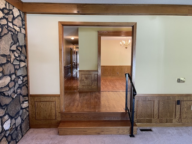 hall with a chandelier and light wood-type flooring