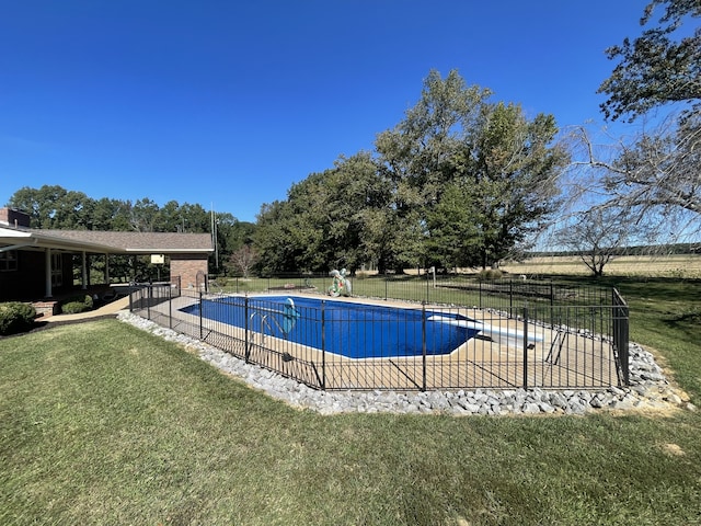 view of swimming pool with a yard