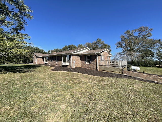 view of front of property with a front yard and a wooden deck