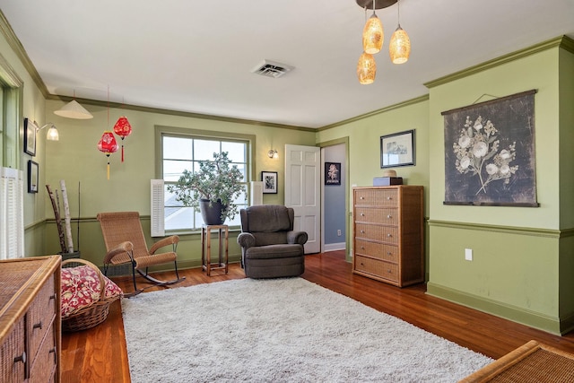 living area featuring crown molding, baseboards, and wood finished floors