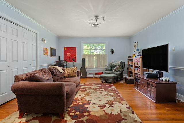 living area with ornamental molding and wood finished floors