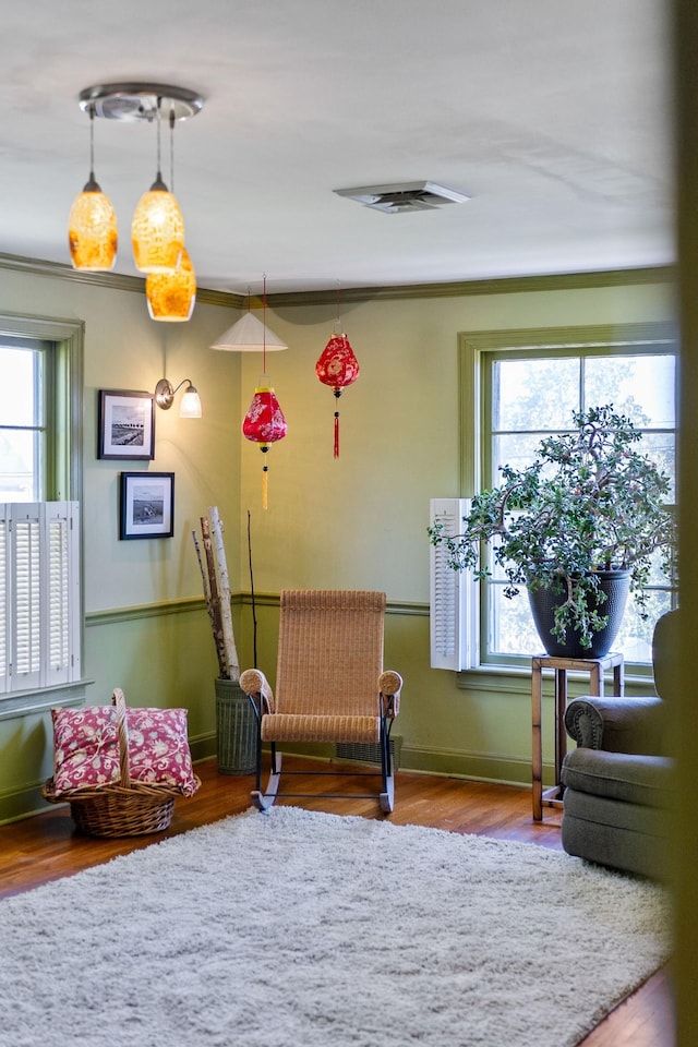 sitting room featuring baseboards, visible vents, a wealth of natural light, and wood finished floors