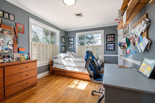bedroom featuring crown molding, baseboards, wood finished floors, and visible vents