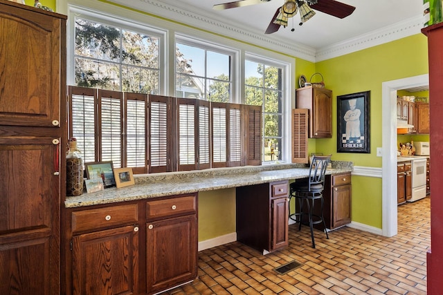 kitchen with ceiling fan, visible vents, white electric range, built in study area, and brick patterned floor