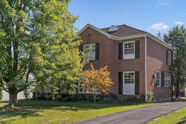 view of front facade featuring brick siding, crawl space, and a front lawn