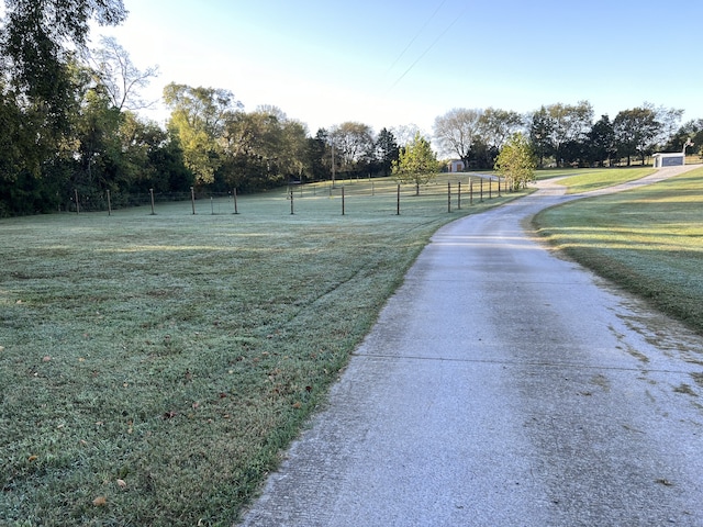 view of property's community featuring a lawn and a rural view