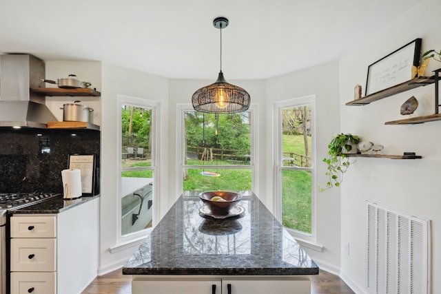 kitchen featuring dark stone countertops, white cabinetry, tasteful backsplash, and dark wood-type flooring