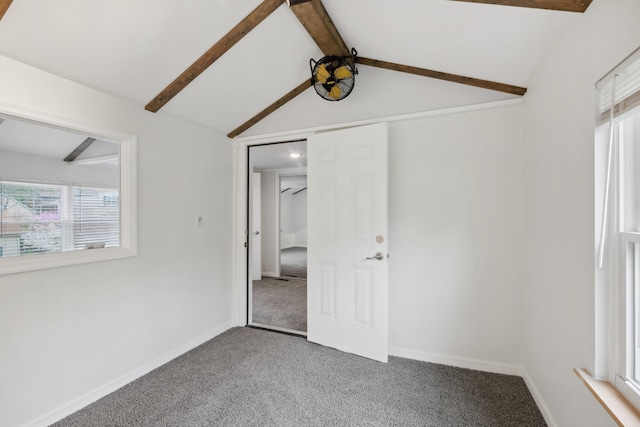 unfurnished bedroom featuring vaulted ceiling with beams and carpet