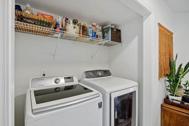 laundry room featuring a textured ceiling and washing machine and clothes dryer