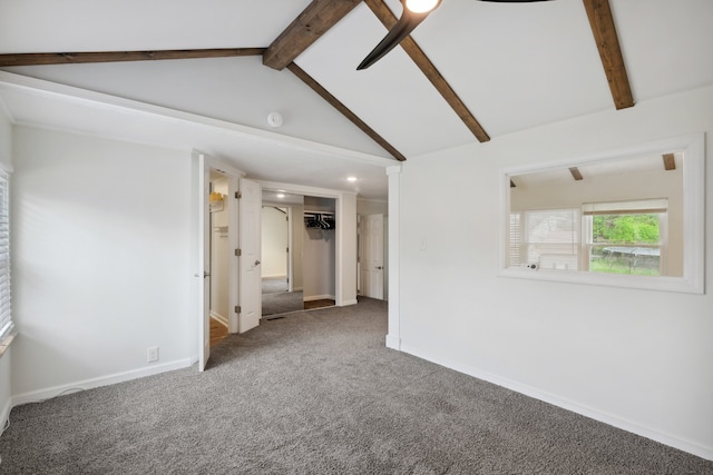 carpeted spare room with vaulted ceiling with beams