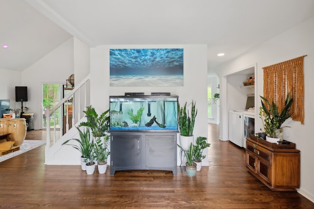 living room with vaulted ceiling, dark hardwood / wood-style flooring, and washer and dryer