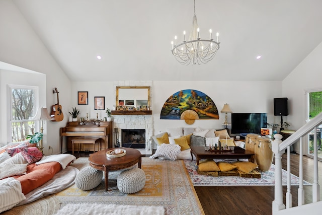 living room with hardwood / wood-style floors, a notable chandelier, a fireplace, and plenty of natural light