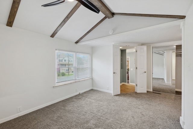 unfurnished bedroom featuring ceiling fan, lofted ceiling with beams, and carpet flooring