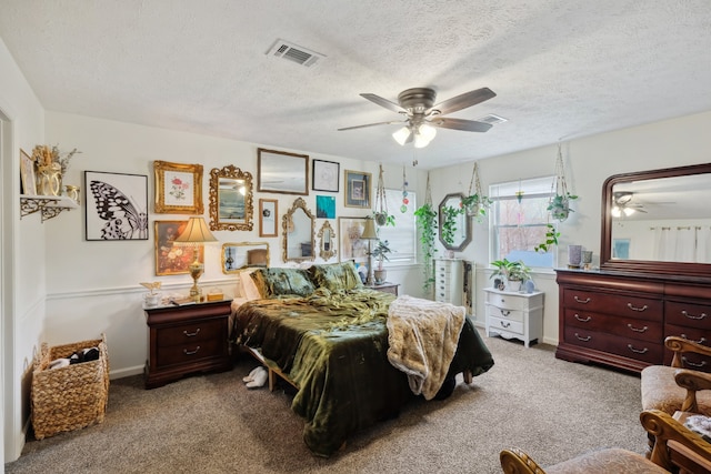 carpeted bedroom with ceiling fan and a textured ceiling