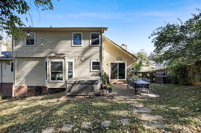 rear view of property with a patio and a lawn